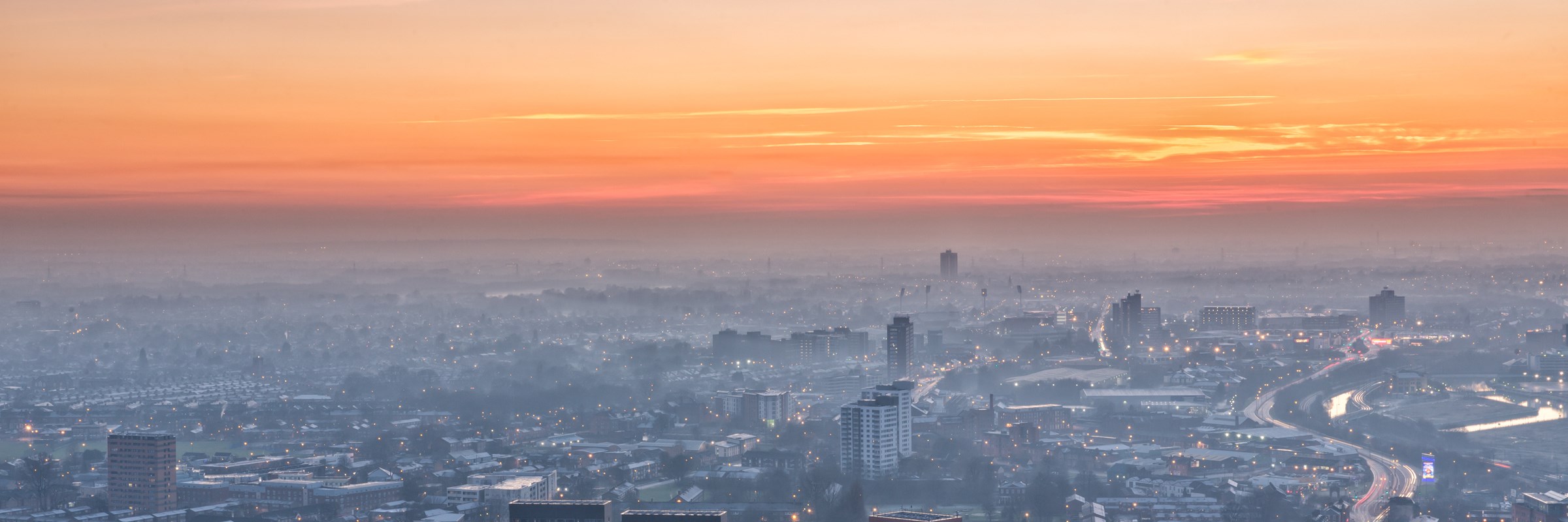 The sun setting over the Greater Manchester skyline