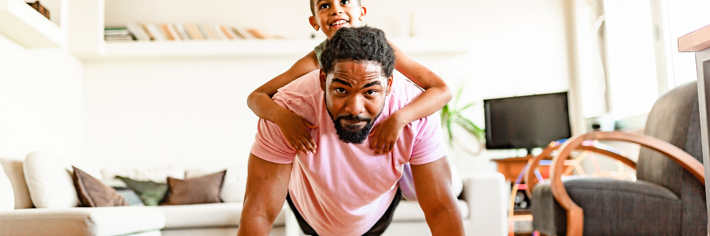 A parent on all fours with a child on their back
