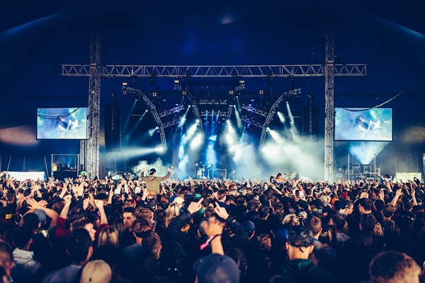 A crowd of people looking towards the stage at a concert