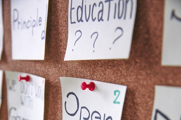post-it notes pinned on a corkboard. The notes read 'open knowledge' and 'community'