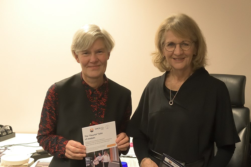 The Deputy Mayor and Assistant Deputy Mayor stood together, smiling, and holding a booklet about Mother Mountain's virtual reality training programme.
