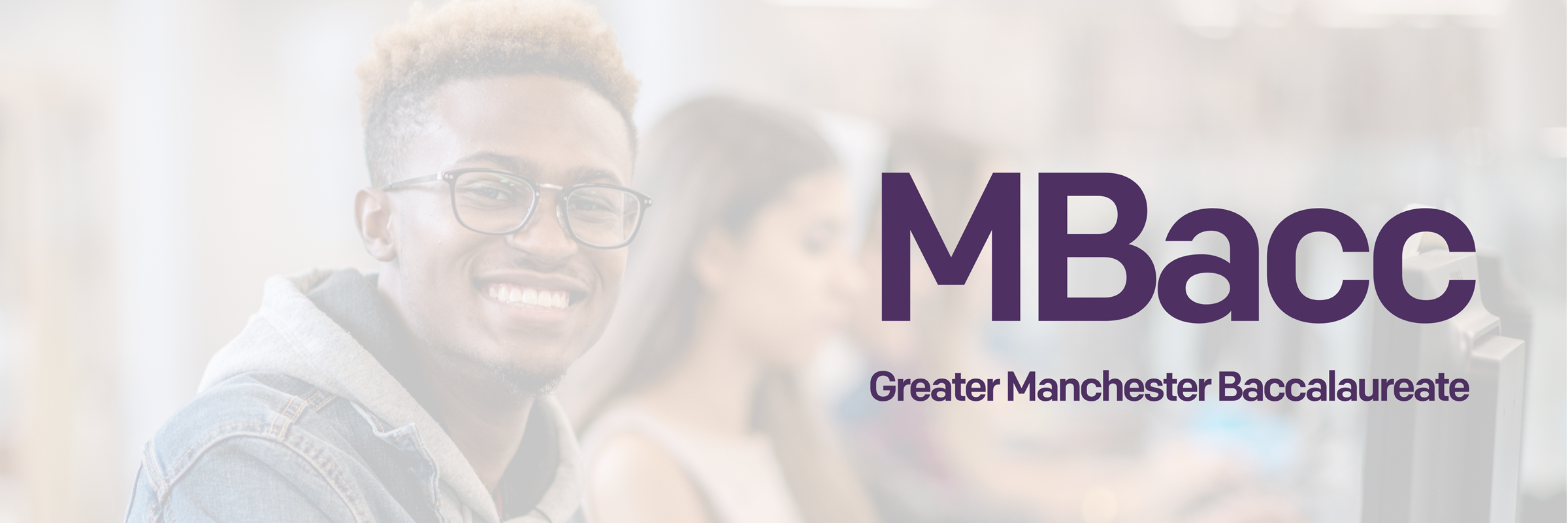 A young person working on a computer with the words "Greater Manchester Baccalaureate" in purple